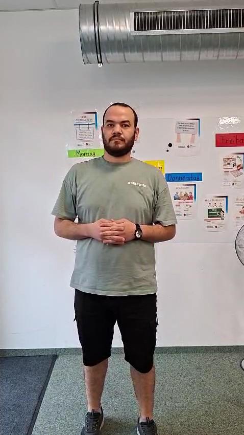 Rayan vor einer Wand mit einem Wochenplan